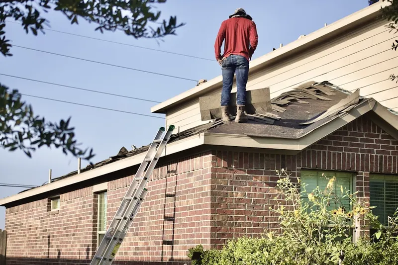 Professional roofer working on a residential roof in Jamestown Village
